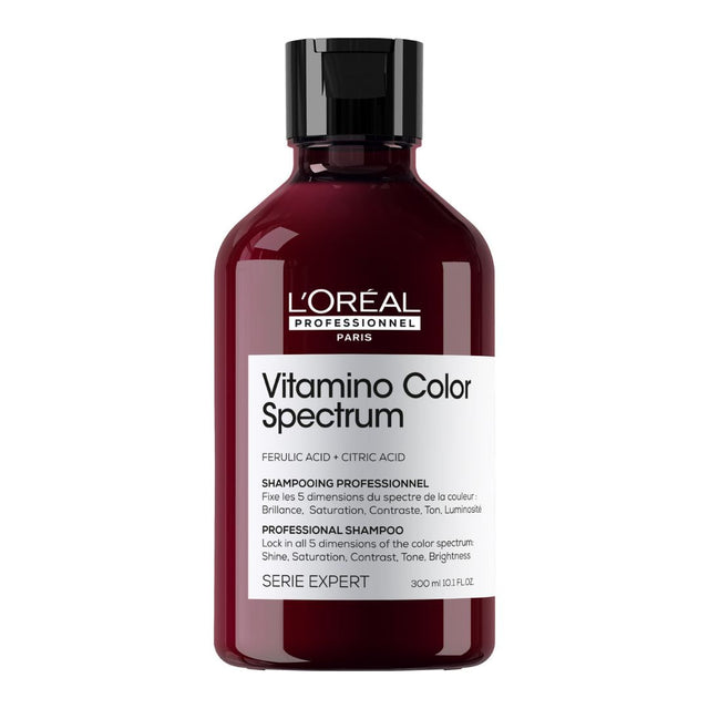 A bottle of L'Oreal Professionnel Vitamino Color Spectrum Shampoo with dark liquid inside and a label that includes the product name and that it is a professional series shampoo.